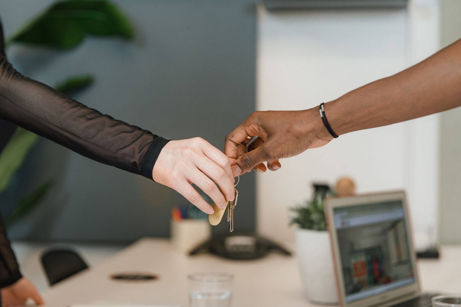 Real estate agent and mortgage advisor exchanging keys with clients